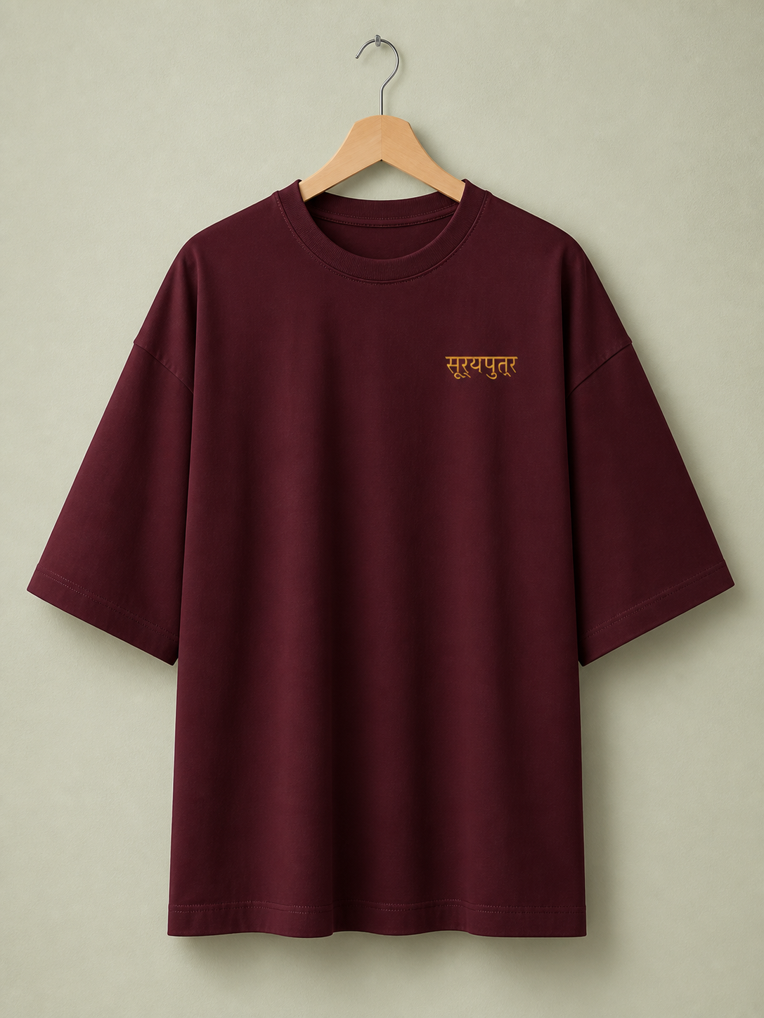 Suryaputra oversized tee in maroon – front chest wordmark on hanger